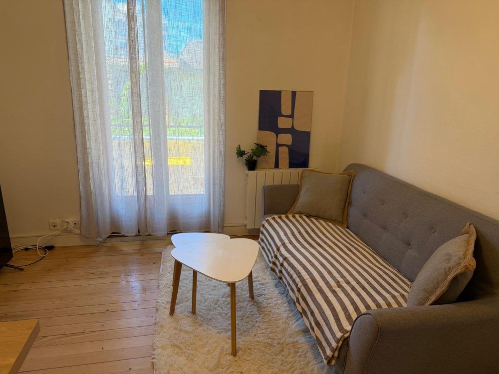 Séjour d'un logement, canapé et table basse, prêt pour l'arrivée