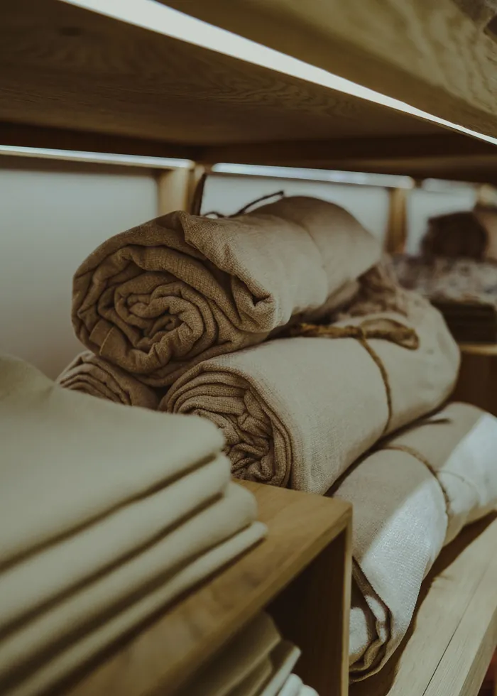 Linge de maison propre, plié et roulé sur une étagère